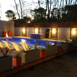 een zwembad met planten voor een gebouw bij Hotel Maritimo in Villa Gesell