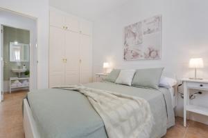 a white bedroom with a bed with a blanket on it at Calida Vivienda Accesible in Caleta De Fuste +18 photos