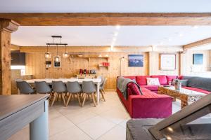 a living room with a red couch and a table at Chalet Vithos en Demi-pension in Les Bruyères