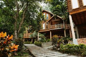 a wooden house with a staircase leading up to it at Cumbres Hotel y Cabañas in Gómez Farías