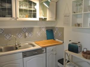 a kitchen with a sink and a cutting board at Kleines Landhaus in Herbstein