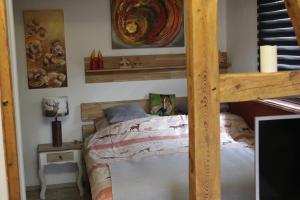 a bedroom with a wooden bunk bed with a ladder at Kleines Landhaus in Herbstein