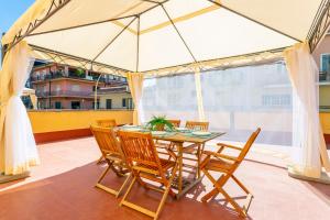 a table and chairs on a balcony with an umbrella at Home Centrum 2 in Giarre