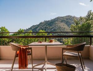 a table and chairs on a balcony with a mountain at Zel Costa Brava in Tossa de Mar