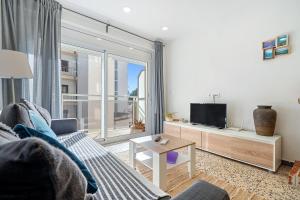 a living room with a couch and a tv at Sonrisita in Miami Platja