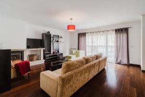 a living room with a couch and a fireplace at Paradise Villa in Esposende
