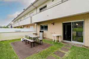 a patio with a table and benches in front of a building at Paradise Villa in Esposende