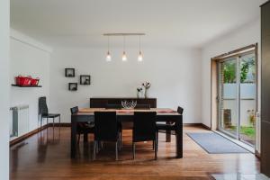 a dining room with a black table and chairs at Paradise Villa in Esposende
