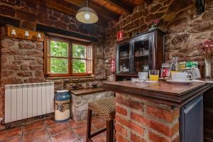 a kitchen with a bar in a stone building at La Pumarada in Villaviciosa