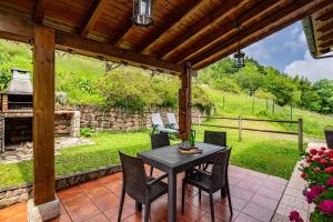 a patio with a table and chairs and a stone wall at La Pumarada in Villaviciosa