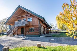 a log cabin with a porch and a balcony at Blockhaus - Ferienwohnung Sunset in Erdmannsdorf