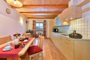 a kitchen with a table with a red table cloth at Gatterpunerhof in Vols am Schlern