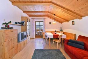 a living room with a red couch and a table at Gatterpunerhof in Vols am Schlern