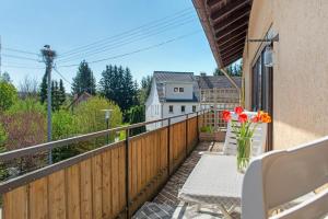 a balcony with a table with flowers on it at Vronis Ferienwohnungen in Mühlingen