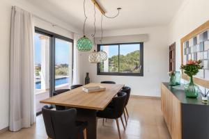 a dining room with a wooden table and chairs at Colonies in Ses Salines