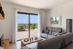 a living room with a couch and a large window at Colonies in Ses Salines