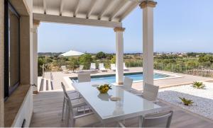 a patio with a white table and chairs and a pool at Colonies in Ses Salines