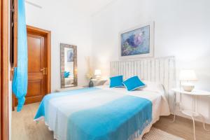 a bedroom with a large bed with blue pillows at Son Amanada in Santa Margalida