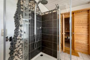 a shower with a glass door in a bathroom at Heimatglück Vulkaneifel mit Sauna in Salm +26 photos
