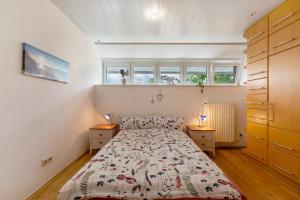 a bedroom with a bed and two windows at Heimatglück Vulkaneifel mit Sauna in Salm