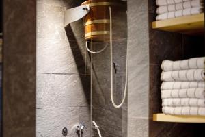 a shower with a hose in a bathroom with towels at K Lodge Mountain in Valdaora +35 photos