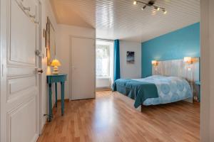 a bedroom with a bed and a blue wall at Kervalou in Sainte Anne d'Auray