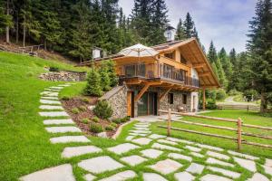 a log home with a walkway leading to a house at K Lodge Mountain in Valdaora
