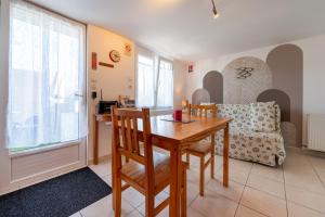 a dining room with a table and a couch at Kervalou in Sainte Anne d'Auray