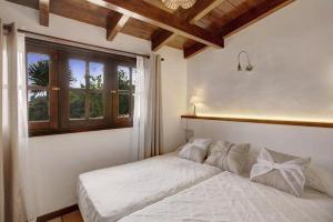a bedroom with a white bed with a window at La Bodega de Julián in Tegueste +37 photos