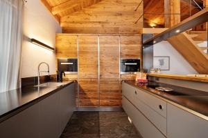 a kitchen with wooden walls and a wooden ceiling at K Lodge Mountain in Valdaora