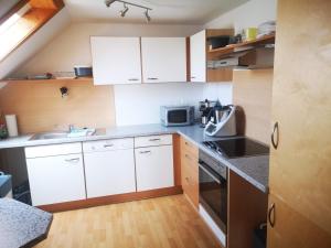 a small kitchen with white cabinets and a sink at Ferienwohnung Eckert in Wehr