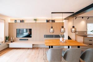 a dining room with a tv and a wooden table at Fewo Tauberblick in Röttingen