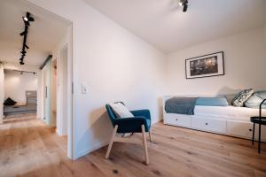 a bedroom with a bed and a chair in it at Fewo Tauberblick in Röttingen