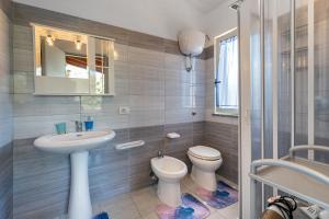 a bathroom with a sink and a toilet and a mirror at Casa Margherita in Nebida +20 photos