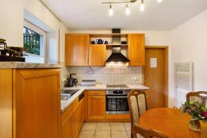 a kitchen with wooden cabinets and a table with a dining room at Ferienwohnung Rotdorn in Schmallenberg