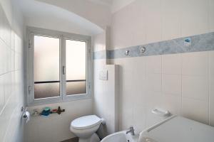 a white bathroom with a toilet and a window at Casa Acqua Mare Parasio in Imperia +15 photos