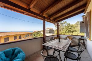 a patio with a table and chairs on a balcony at Casa Margherita in Nebida