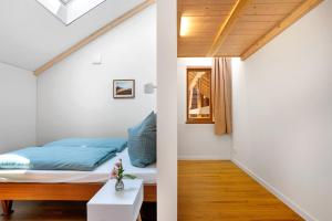 a bedroom with a bed and a white wall at Ferienwohnung Marie in Egling