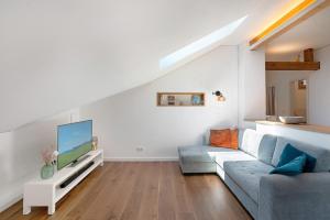 a living room with a blue couch and a tv at Ferienwohnung Marie in Egling
