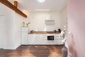 a white kitchen with a sink and a refrigerator at Ferienwohnung Marie in Egling