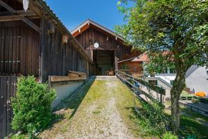 a barn with a dirt road leading into it at Ferienwohnung Marie in Egling