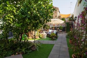 a garden with a couch and trees and flowers at A Ugghia in Fiumefreddo di Sicilia