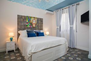 a bedroom with a large bed with blue pillows at A Ugghia in Fiumefreddo di Sicilia