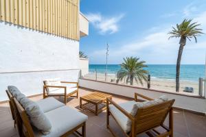 a balcony with chairs and tables and a view of the ocean at Calafellmar loft in Calafell