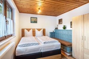 a bedroom with a bed and a wooden ceiling at Am Wehrastrand App Eg in Todtmoos