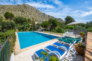 a swimming pool with lounge chairs and a mountain at Villa Piedra in Pollença