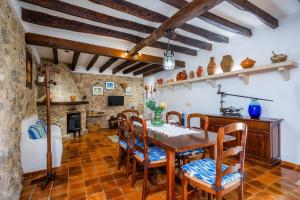 a dining room with a table and chairs and a fireplace at Villa Piedra in Pollença