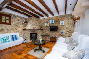 a living room with a white couch and a fireplace at Villa Piedra in Pollença
