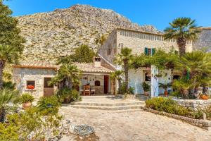 an exterior view of a house with palm trees at Villa Piedra in Pollença