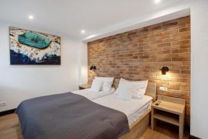 a bedroom with a bed and a brick wall at Heimelige Schwarzwaldwohnung Stein in Häusern